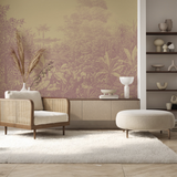 A styled interior room featuring a large wall mural with a botanical toile-style jungle pattern in muted mauve and beige tones. The room includes a rattan armchair with a cream cushion, a low ribbed sideboard with white ceramic decor, a white shag rug, and a round off-white ottoman.