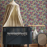 Black crib with canopy in a room with floral wallpaper and round rug